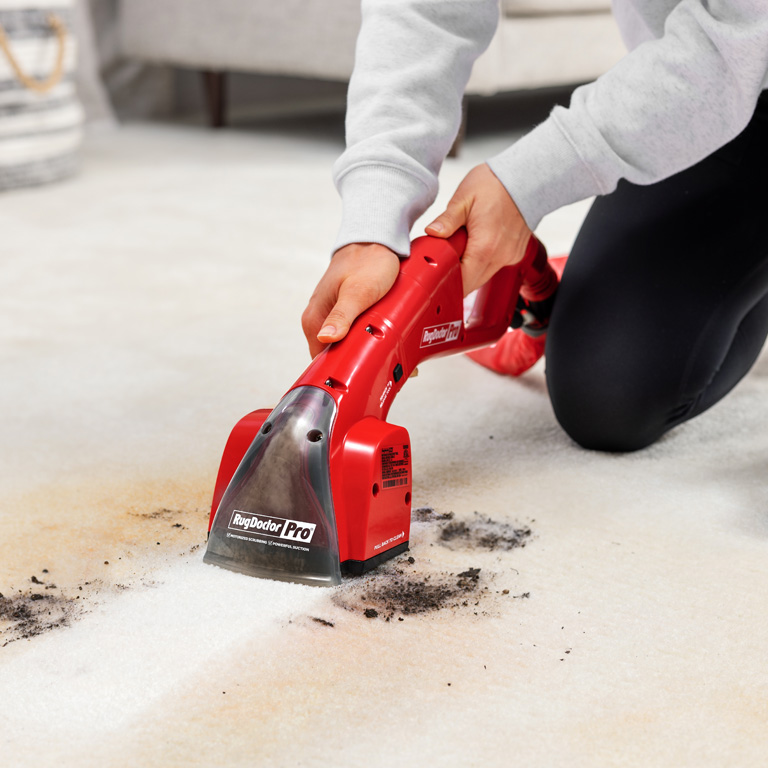 Clean carpet stains with motorized tool